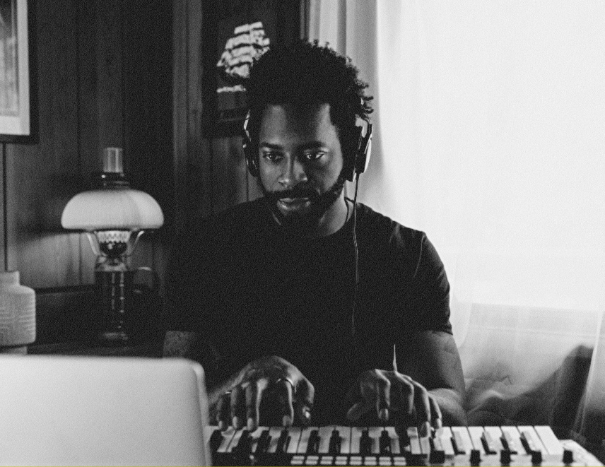 Producer playing a MIDI keyboard in a home studio